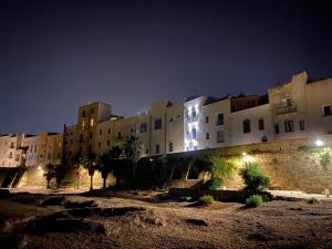 un gruppo di edifici di notte con luci di Le Mura a Trapani