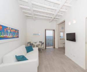 ein weißes Wohnzimmer mit einem weißen Sofa und einem Tisch in der Unterkunft Le Mura in Trapani