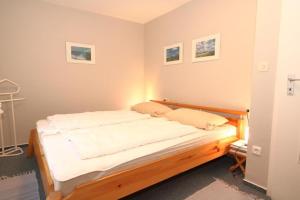 a bedroom with a wooden bed in a room at Caecilia-Bangert in Wenningstedt
