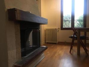 a living room with a fireplace and a window at Ô Cottage in Deuil-la-Barre
