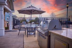 a patio with a grill and a table with an umbrella at TownePlace Suites Medford in Medford