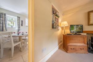 een woonkamer met een televisie op een houten tafel bij Densford Cottage in Amberley