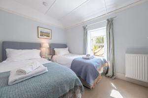 een slaapkamer met twee bedden en een raam bij Densford Cottage in Amberley