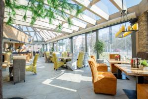 un restaurante con mesas, sillas y ventanas en Hotel Tanne Ilmenau en Ilmenau