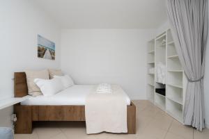een slaapkamer met een bed met een tafel en planken bij Sunny Studio W/ Balcony in Portimão by LovelyStay in Portimão