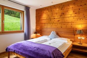 ein Schlafzimmer mit einer Holzwand und einem großen Bett in der Unterkunft Haus Tirol Apt Lausgitsch in Lajen