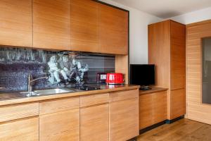 een keuken met houten kasten, een wastafel en een tv bij Haus Tirol Apt Lausgitsch in Laion