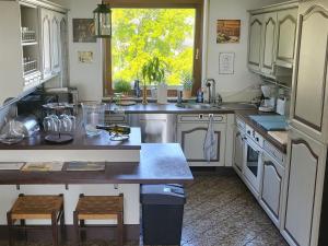 Una cocina con gabinetes blancos y una ventana grande. en Ferienwohnung Buenavista, en Neustadt an der Weinstraße 33 fotos más