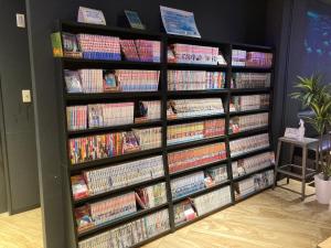 a book shelf filled with lots of books at Henn na Hotel Osaka Namba in Osaka