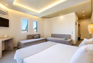a bedroom with a bed and a couch and a tv at Green Bay in Limenaria