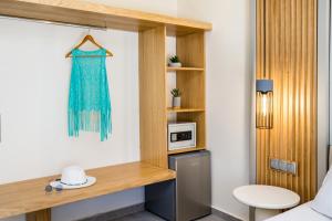 a room with a bed and a desk with a microwave at Green Bay in Limenaria