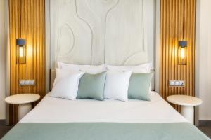 a bedroom with a large white bed with two tables at Green Bay in Limenaria