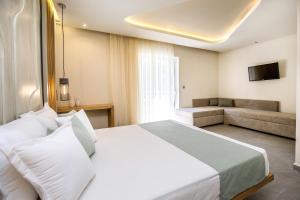 a hotel room with a bed and a couch at Green Bay in Limenaria