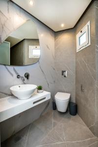 a bathroom with a sink and a toilet at Green Bay in Limenaria