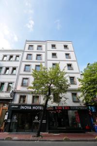 un edificio blanco con un árbol delante en Grand Inova Hotel en Estambul