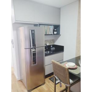 Il comprend une cuisine équipée d'un réfrigérateur en acier inoxydable et d'une table. dans l'établissement Flat Studio Granja Viana Completo 411, à Cotia