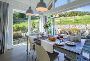 a dining room with a table and chairs and a large window at Brooks Lodge Sussex in Tarring Neville