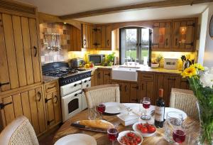 a kitchen with a table with glasses of wine at Field Cottage in Little Comberton