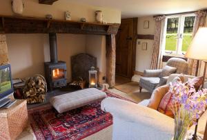 a living room with a wood stove in a living room at Field Cottage in Little Comberton