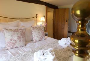 a bedroom with a bed with white sheets and pillows at Field Cottage in Little Comberton