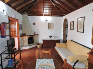 un soggiorno con divano e camino di Casas Rurales Casitas Armary, en San Isidro, Breña Alta a Breña Alta
