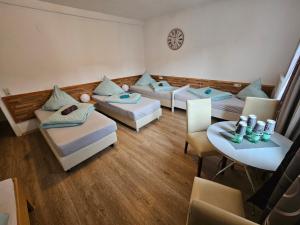 ein Wohnzimmer mit Sofas, einem Tisch und Stühlen in der Unterkunft Hotel & Hostel Albstadt in Albstadt