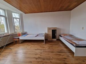 a room with two beds and a wooden ceiling at K&K Unterkunft GbR, Wohunung 3 in Duisburg