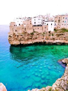 a group of buildings on a cliff above the water at Dimora Sportelli in Polignano a Mare