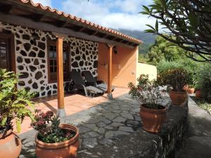 une terrasse avec des plantes en pot devant une maison dans l'établissement Casas Rurales Casitas Armary, en San Isidro, Breña Alta, à Breña Alta