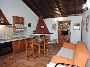 cocina y sala de estar con mesa y sillas en Casas Rurales Casitas Armary, en San Isidro, Breña Alta en Breña Alta