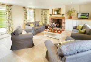uma grande sala de estar com sofás e uma lareira em Rampisham Hill Farm Barn em Hooke