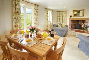 uma sala de jantar com uma mesa de madeira e uma sala de estar em Rampisham Hill Farm Barn em Hooke