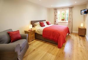 1 dormitorio con cama, sofá y ventana en Rampisham Hill Farm Barn, en Hooke
