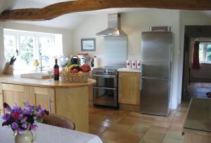 a kitchen with a stainless steel refrigerator and a counter at Pear Tree Cottage Norfolk in Little Barningham