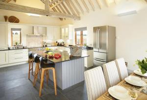 a kitchen with a large island in the middle of it at Furlong Barn in Southam