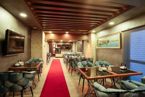 un restaurante con mesas y sillas y alfombra roja en Grand Inova Hotel en Estambul
