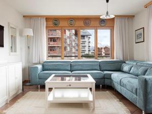 a living room with a blue couch and a table at Apartment Ambassador I Apt 7 by Interhome in Nendaz