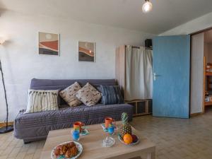 a living room with a blue couch and a table at Studio Los Amigos-6 by Interhome in Le Grau-du-Roi