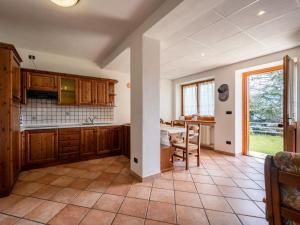 eine Küche mit Holzschränken und einem Tisch in der Unterkunft Apartment Renard by Interhome in Sarre