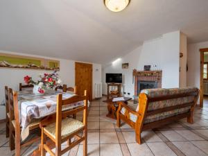 a dining room with a table and chairs and a fireplace at Apartment Marmotte by Interhome in Sarre