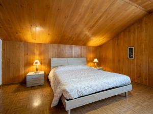 SarreにあるApartment Marmotte by Interhomeの木製の壁のベッドルーム1室(大型ベッド1台付)