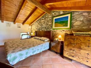 a bedroom with a bed and a stone wall at Apartment Cà del Fritz by Interhome in Sorico