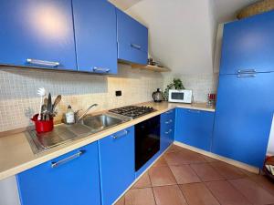 a kitchen with blue cabinets and a sink at Apartment Cà del Fritz by Interhome in Sorico