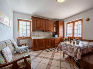 een keuken met houten kasten en een tafel en een bank bij Apartment Hérisson by Interhome in Sarre