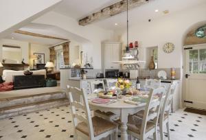 a kitchen with a white table and chairs in a room at Coach House Hawling in Hawling