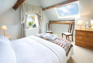 a bedroom with a white bed and a large mirror at Coach House Hawling in Hawling