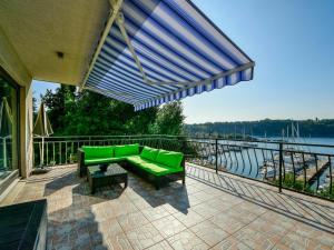 a green couch on a patio with a view of the water at Apartment Marija by Interhome in Omišalj