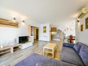 a living room with a blue couch and a table at Apartment Marija-1 by Interhome in Omišalj +22 photos