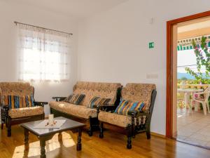 ein Wohnzimmer mit zwei Stühlen und einer Couch und einem Tisch in der Unterkunft Apartment Andjelka by Interhome in Malinska