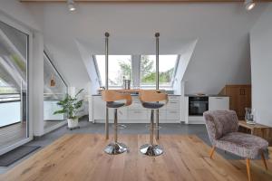 a kitchen with two stools and a table and chairs at Ferienwohnung Carpe Diem in Füssen +16 photos